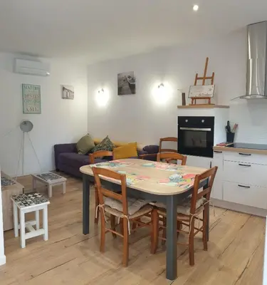 a kitchen and living room with a table and chairs at L'Annexe in Sigean