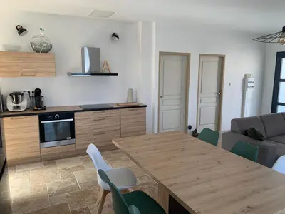 a kitchen and dining room with a wooden table and chairs at Villa 18 in Narbonne