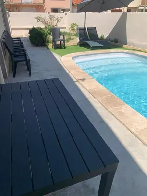a swimming pool with chairs and a bench next to it at Villa 18 in Narbonne