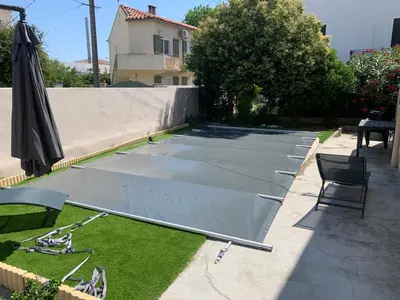 a metal cover on a patio with a chair and an umbrella at Villa 18 in Narbonne