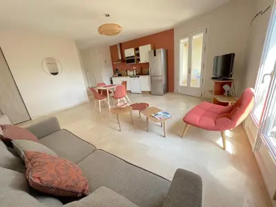 a living room with a couch and chairs and a kitchen at Au point du jour - Gîtes Carcassonne, Lac de la Cavayère in Carcassonne