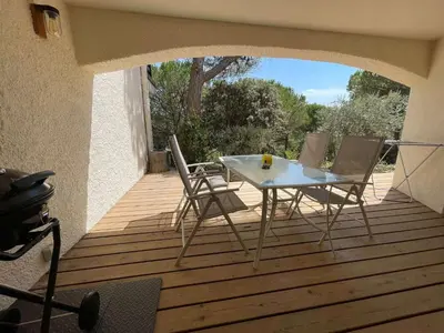 a table and chairs sitting on a wooden deck at Au point du jour - Gîtes Carcassonne, Lac de la Cavayère in Carcassonne