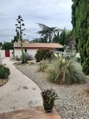 a garden with a walkway and plants and a house at Tranquillité Gite in Cuxac-dʼAude