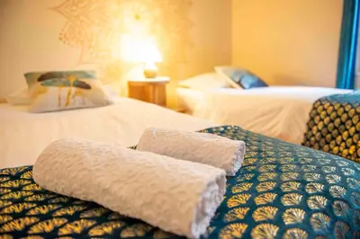 a hotel room with two beds with white sheets at Autour d'une Toile in Rouvenac