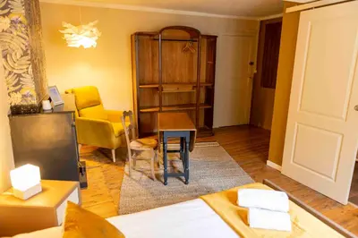 a living room with a bed and a table and chairs at Autour d'une Toile in Rouvenac