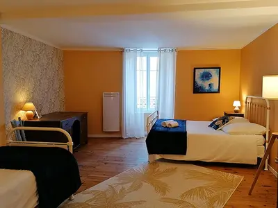a hotel room with two beds and a window at Autour d'une Toile in Rouvenac