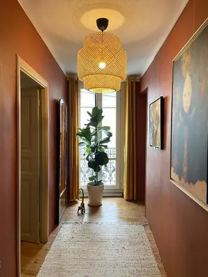 a hallway with a potted plant and a large window at Autour d'une Toile in Rouvenac