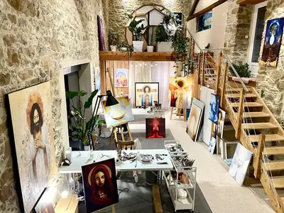 a room with paintings on the walls and a staircase at Autour d'une Toile in Rouvenac