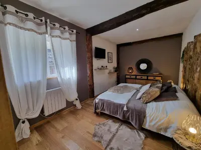 a bedroom with a large bed and a window at LE GITE SPA DU CEDRE BLEU in La Tourette-Cabardès