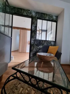 a living room with a glass table and a couch at LE GITE SPA DU CEDRE BLEU in La Tourette-Cabardès