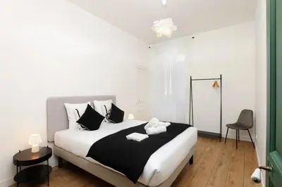 a bedroom with a large bed with black and white pillows at La Pittoresque 1 in Carcassonne