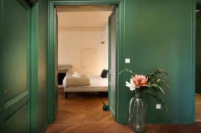 a vase with flowers in a room with a bed at La Pittoresque 1 in Carcassonne