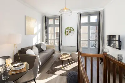 a living room with a couch and a table at N1 Des Études Cosy Duplex Netflix Balcon ConciergerieDameCarcas in Carcassonne