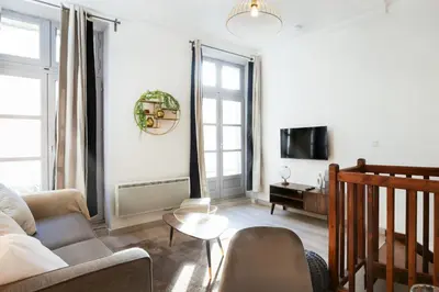 a living room with a couch and a tv at N1 Des Études Cosy Duplex Netflix Balcon ConciergerieDameCarcas in Carcassonne