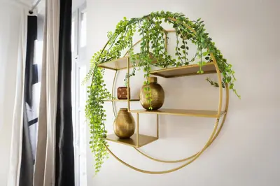 a round gold shelf with vases and a plant at N1 Des Études Cosy Duplex Netflix Balcon ConciergerieDameCarcas in Carcassonne