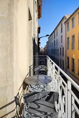 a balcony with tables and chairs on a building at N1 Des Études Cosy Duplex Netflix Balcon ConciergerieDameCarcas in Carcassonne