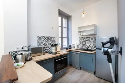 a kitchen with blue cabinets and a refrigerator at N1 Des Études Cosy Duplex Netflix Balcon ConciergerieDameCarcas in Carcassonne