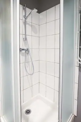 a bathroom with a shower with a glass door at N2 des Études Cosy Hypercentre Wifi ConciergerieDameCarcas in Carcassonne
