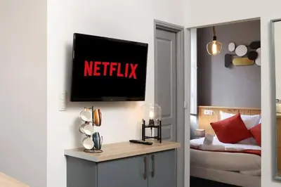 a living room with a television on a wall at N2 des Études Cosy Hypercentre Wifi ConciergerieDameCarcas in Carcassonne