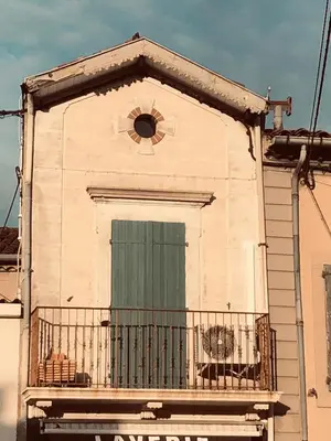 a building with a green door and a balcony at Appart 55 in Mazamet