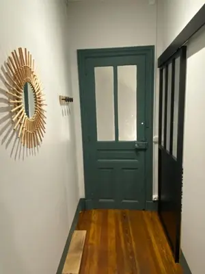 a green door and a mirror in a hallway at Appart 55 in Mazamet