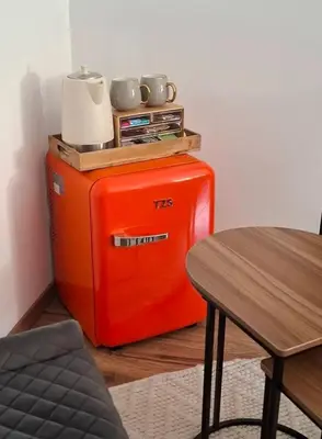 an orange refrigerator sitting in a room with a table at Le Mas Victoria - Chambres d'hôtes avec table d'hôtes-Parking privé ferme in Carcassonne