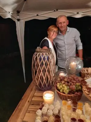 a man and woman standing next to a table of food at Le Mas Victoria - Chambres d'hôtes avec table d'hôtes-Parking privé ferme in Carcassonne