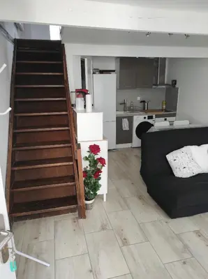 a living room with a staircase leading to a kitchen at T2 Duplex Pamiers Plein Centre - Logement entier - Nouveau in Pamiers