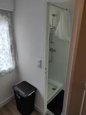 a bathroom with a shower and a black trash can at T2 Duplex Pamiers Plein Centre - Logement entier - Nouveau in Pamiers