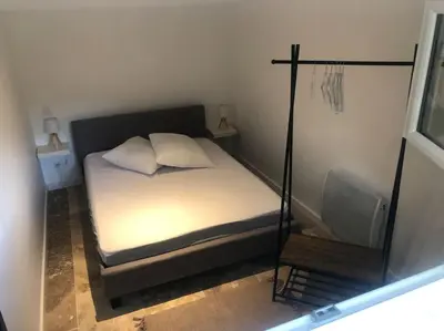 a small bedroom with a bed and a mirror at Bienvenue « À l’ombre du figuier » in Pieusse