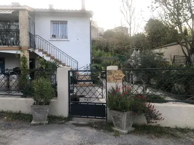 a gate to a house with two potted plants at Bienvenue « À l’ombre du figuier » in Pieusse