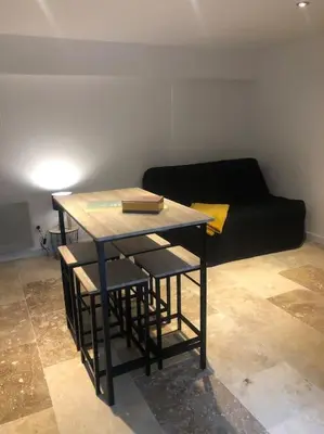 a table and chairs in a room with a couch at Bienvenue « À l’ombre du figuier » in Pieusse