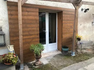 a wooden entrance to a house with a door at Bienvenue « À l’ombre du figuier » in Pieusse
