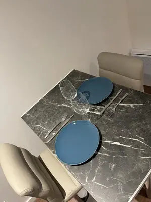 a table with blue plates and wine glasses on it at Les Appartements du Cep’t in Mazamet