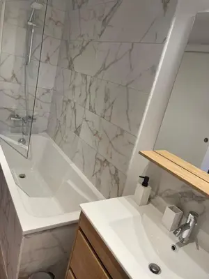 a bathroom with a white tub and a sink at Les Appartements du Cep’t in Mazamet