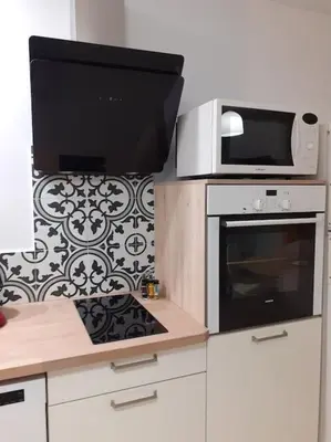 a kitchen with a microwave and a stove at L'Ancestrale, Beau T2 in Limoux