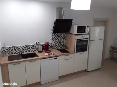a kitchen with white cabinets and a white refrigerator at L'Ancestrale, Beau T2 in Limoux
