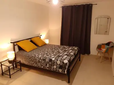 a bedroom with a bed with yellow and orange pillows at L'Ancestrale, Beau T2 in Limoux