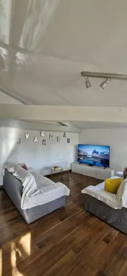 a bedroom with two beds and a flat screen tv at La Robine in Narbonne