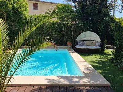 a swimming pool in a yard with a chair and a table at La maison des Vendangeurs 10 in Olonzac