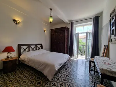 a bedroom with a bed and a large window at La maison des Vendangeurs 10 in Olonzac
