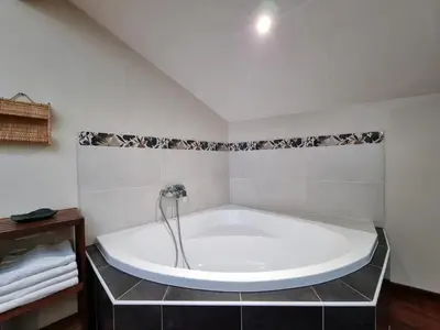 a large white bath tub in a bathroom at La maison des Vendangeurs 10 in Olonzac