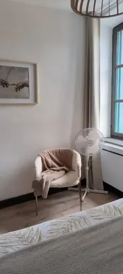 a room with a chair and a table and a window at Appartement sous les remparts in Carcassonne