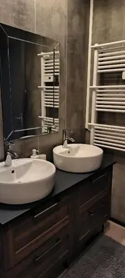 a bathroom with two sinks and a large mirror at Appartement sous les remparts in Carcassonne