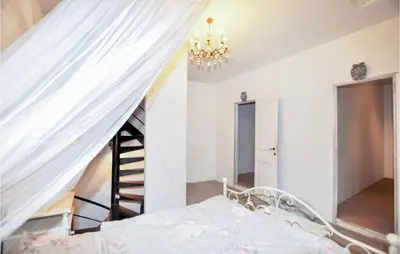 a bedroom with a bed with a chandelier at Gorgeous Home In Villeseque Des Corbier in Villesèque-des-Corbières