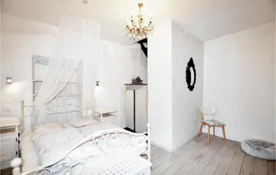 a white bedroom with a bed and a chandelier at Gorgeous Home In Villeseque Des Corbier in Villesèque-des-Corbières