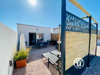 a patio with a wooden fence and a table at Gîte & Spa Le Villemachois - 4 étoiles - Jacuzzi couvert - Calme et Indépendant - Clim - Parking - 5 min Carcassonne in Villemoustaussou