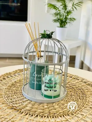 a bird cage with candles and chopsticks on a table at Gîte & Spa Le Villemachois - 4 étoiles - Jacuzzi couvert - Calme et Indépendant - Clim - Parking - 5 min Carcassonne in Villemoustaussou
