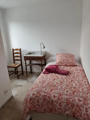a bedroom with a bed and a table and a chair at Le Rocher au Thym in Limoux