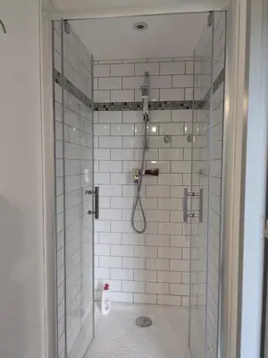 a bathroom with a shower with white tiles at Le Rocher au Thym in Limoux